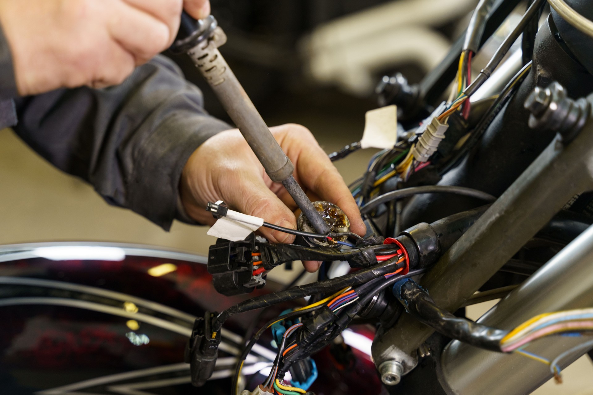 Electrician soldering electrical wires to electrical equipment.