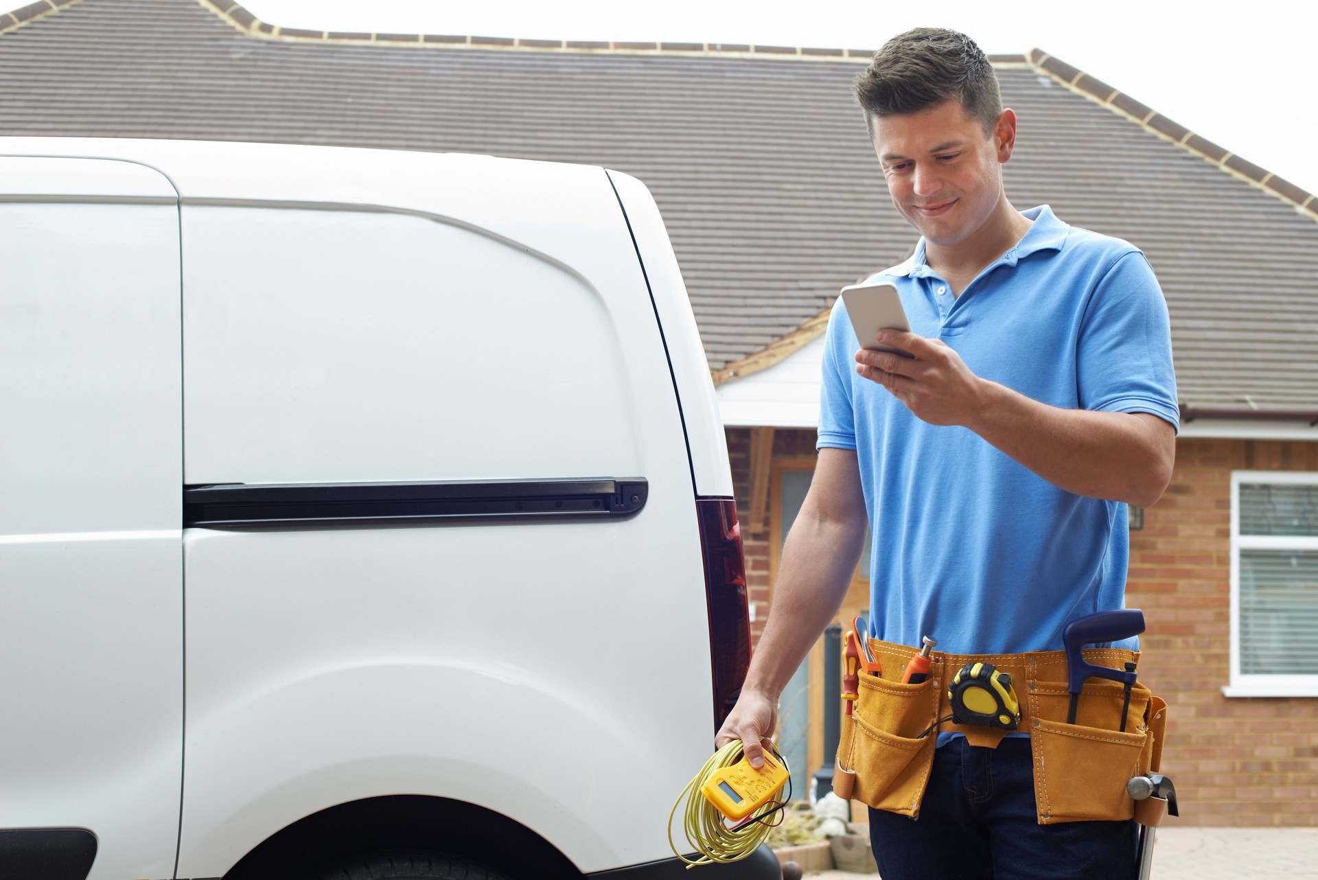 Electrician Checking Message On Mobile Phone